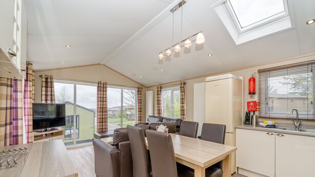 Una cocina moderna con comedor, televisor y vistas al exterior.