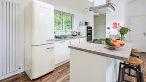A modern kitchen with white cabinetry, a built-in stove, and a window overlooking greenery. - 2 bedroom accommodation in Wootton Bridge, Nr Cowes (Wootton Bridge, Nr Cowes)