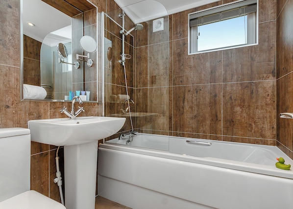 Une salle de bain moderne avec une baignoire, un lavabo et une douche.