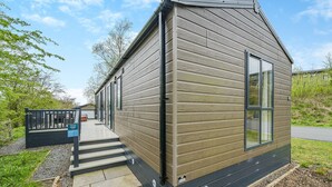 A small, single-story building with a sloped roof, a front door, and a window. - 1 bedroom accommodation in Bewaldeth, Keswick (Bewaldeth, Keswick)