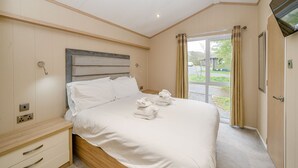 A hotel room with a bed, a TV, a window, and a door. - 1 bedroom accommodation in Bewaldeth, Keswick (Bewaldeth, Keswick)