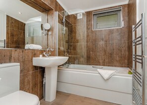A modern bathroom with a white sink, a bathtub, and a shower. - 4 bedroom accommodation in Cheddar (Cheddar)