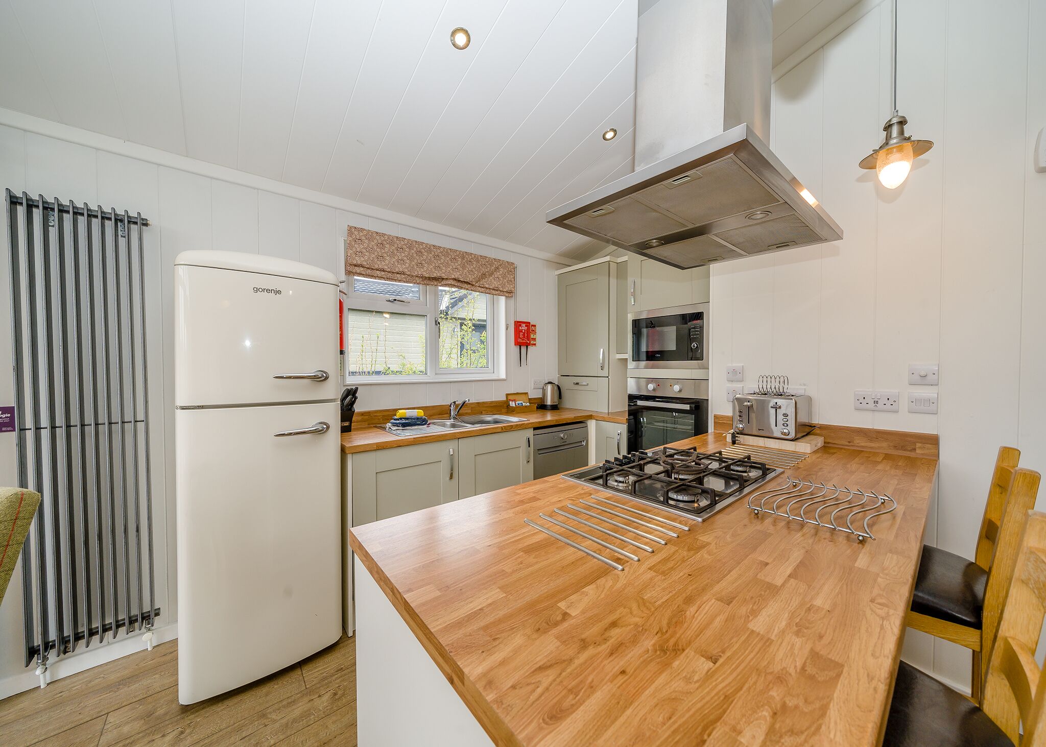 A modern kitchen with a central island, stainless steel appliances, and a window with a view.
