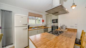 A modern kitchen with a central island, stainless steel appliances, and a window with a view.