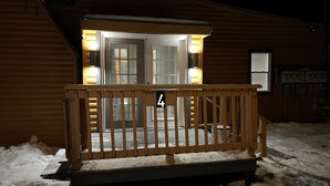A wooden building with a balcony and a number '4' sign, surrounded by snow.
