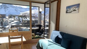Una habitación con un ventanal que ofrece vistas a un paisaje montañoso nevado.