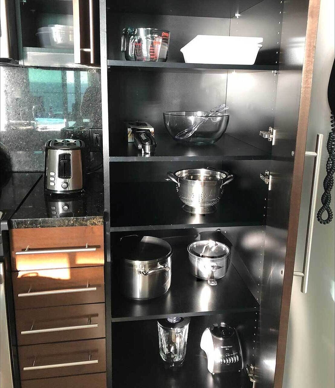 Una cocina con electrodomésticos de acero inoxidable, incluyendo un tostador, una tetera y un colador.