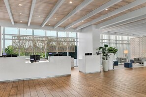 Welcome to our reception area, featuring a high ceiling, large windows, and a seating area with modern furniture.
