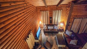A log cabin interior with a wooden ceiling, a sofa, a table, and a lamp. - "The Northern Star" Townhouse @ Snowshoe on Raven Golf Course (Snowshoe)