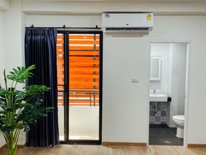Una habitación con puerta corredera, aire acondicionado, lavamanos y retrete.