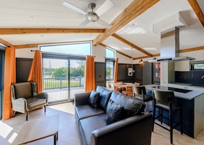 A modern interior with a sofa, dining table, and kitchen area.