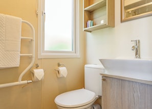 A bathroom with a toilet, a sink, a towel rack, and a window. - 2 bedroom accommodation in Sandymouth Bay, Bude (Sandymouth Bay, Bude)