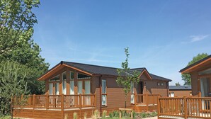 Une rangée de chalets en bois dotés de balcons, un chemin pavé et un ciel dégagé.