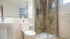 Ein Badezimmer mit Duschkabine, Toilette und Waschbecken.