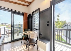 Un balcón con una mesa, sillas y vistas al exterior.
