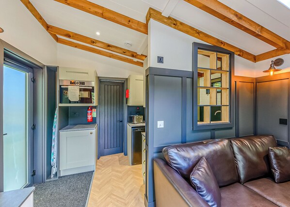 Un espace de vie compact comprenant un coin cuisine, un canapé et une fenêtre avec vue.