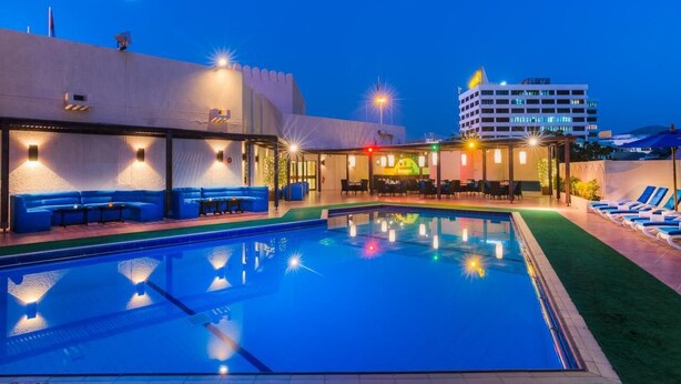 Une piscine dotée de chaises longues et d’un espace bar.