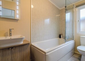 A bathroom with a sink, mirror, vanity, bathtub, shower, and toilet. - 1 bedroom accommodation in Canterbury (Canterbury)