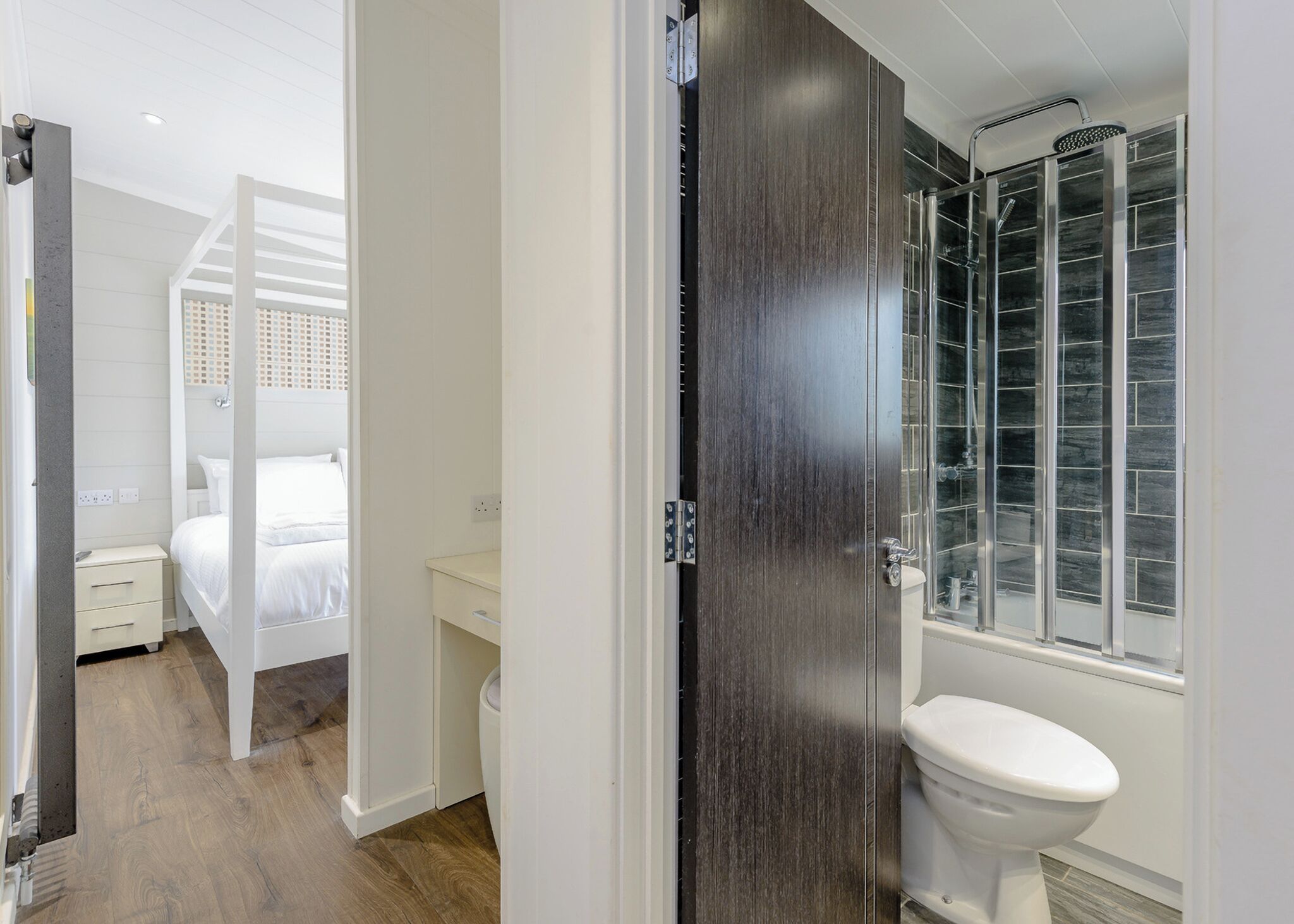 A modern bathroom with a shower, toilet, and a walk-in closet.