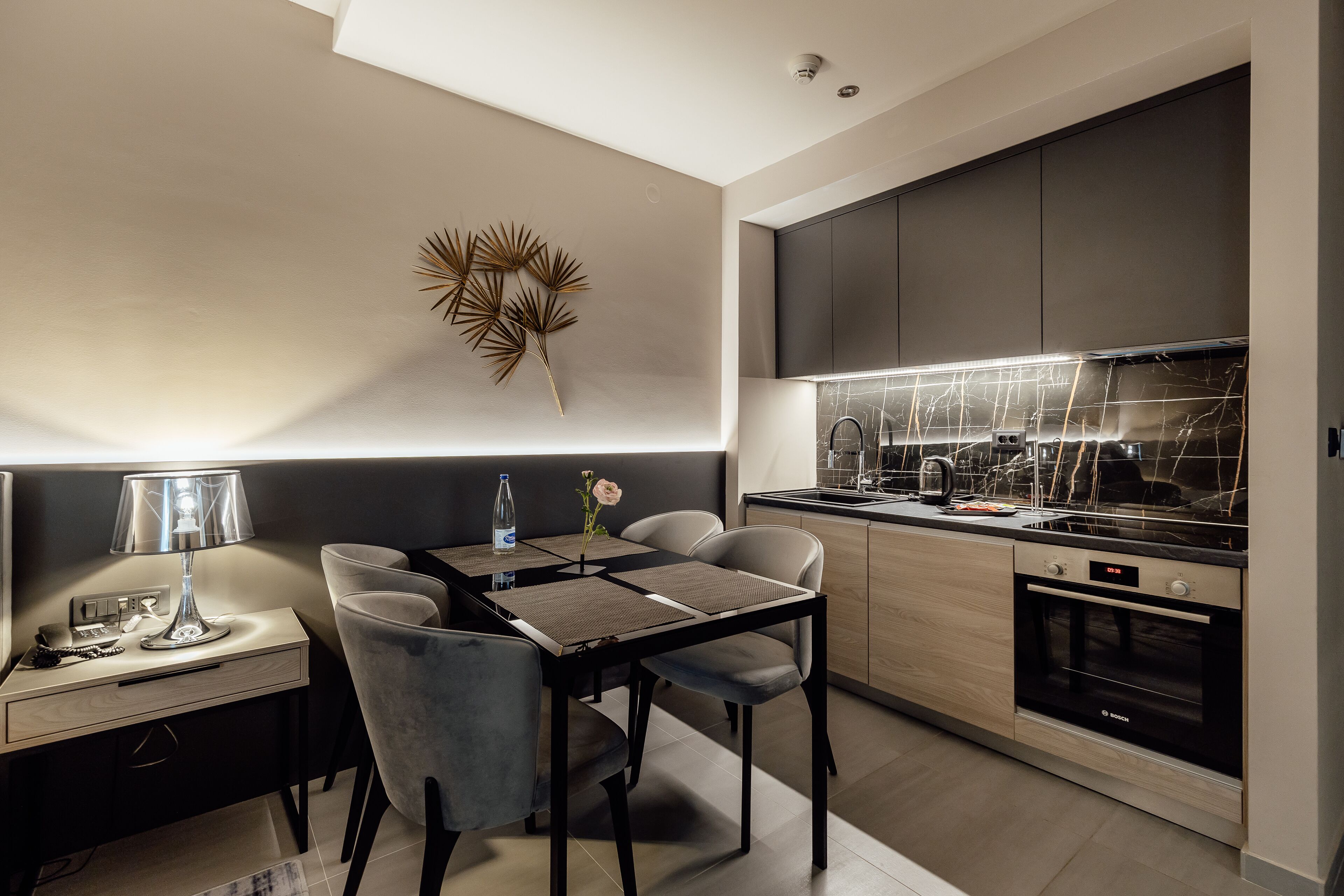 Una cocina moderna con comedor, que incluye un horno Bosch, salpicadero de mármol y un diseño minimalista.