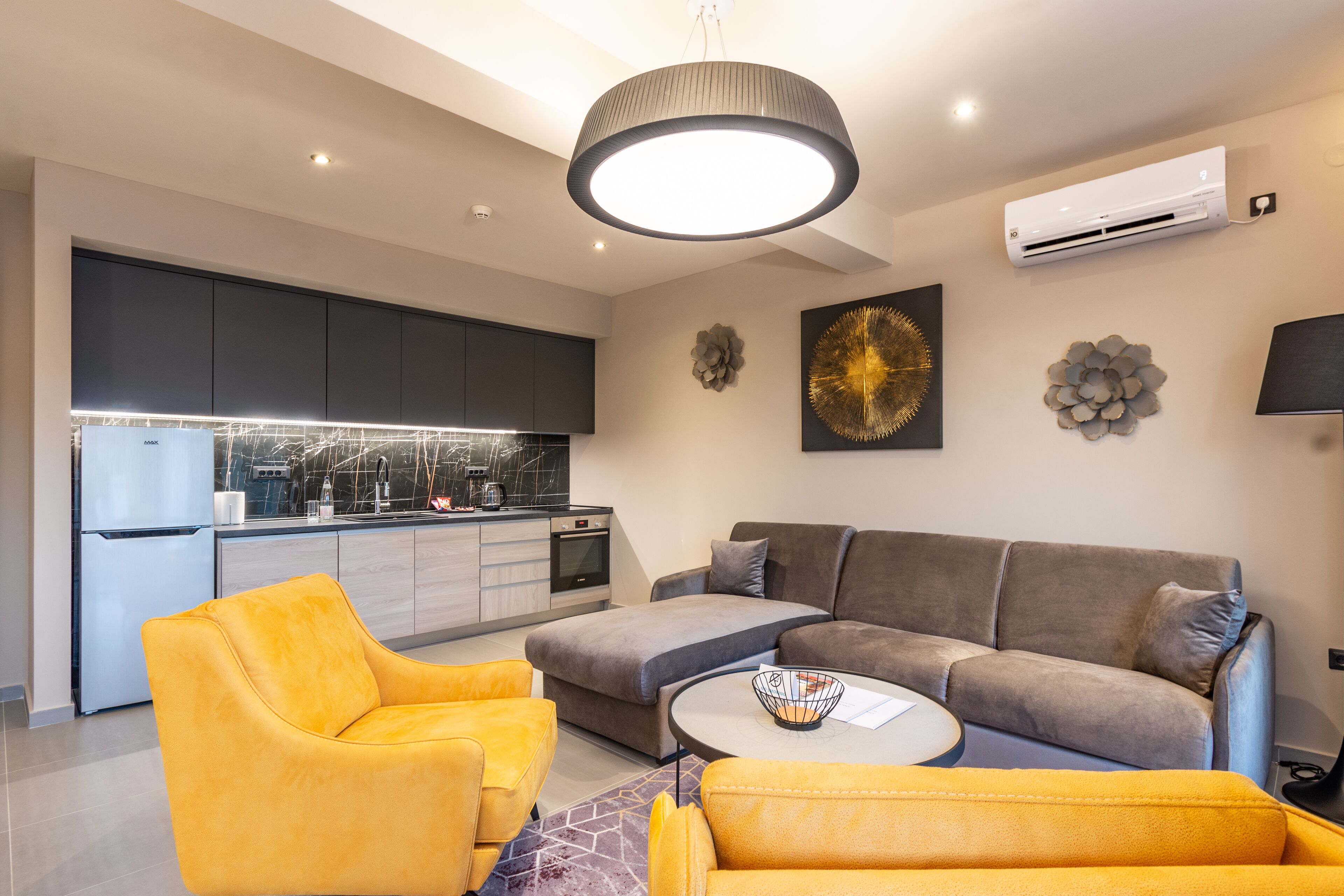 Uma sala de estar moderna com um sofá, poltronas amarelas e uma mesa de centro.