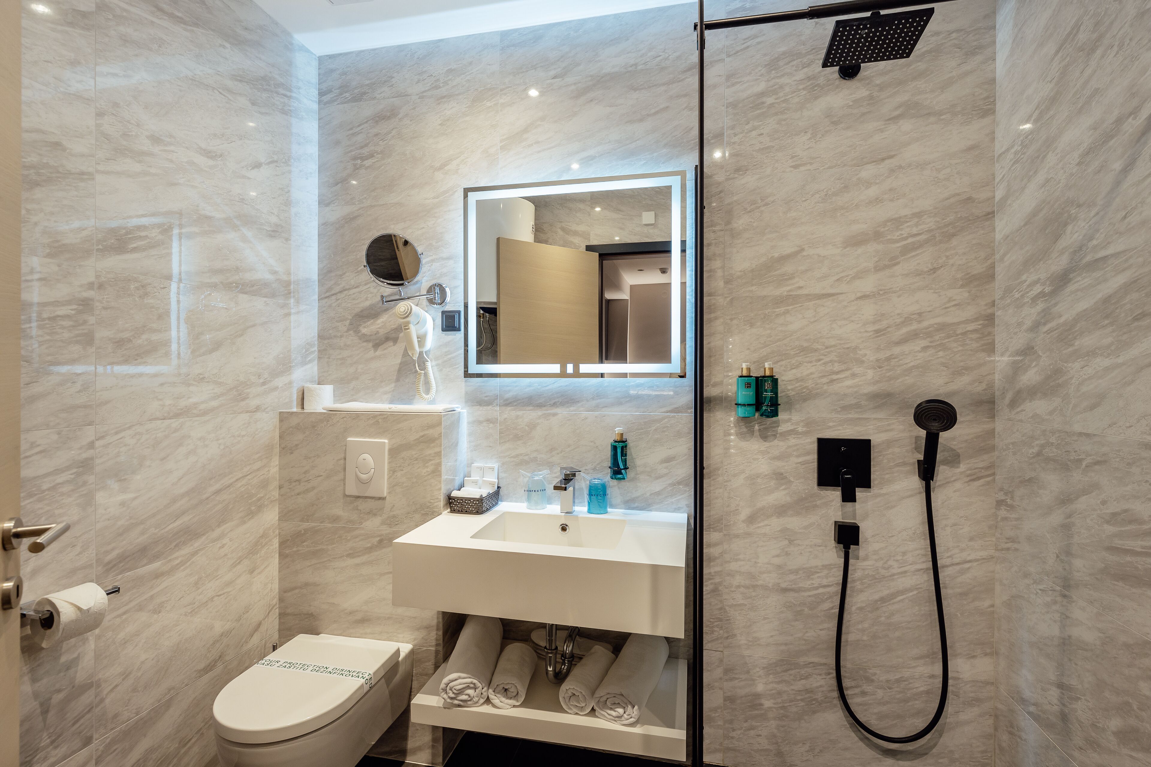 A modern bathroom with a toilet, sink, and shower.