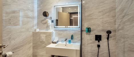 A modern bathroom with a toilet, sink, and shower.