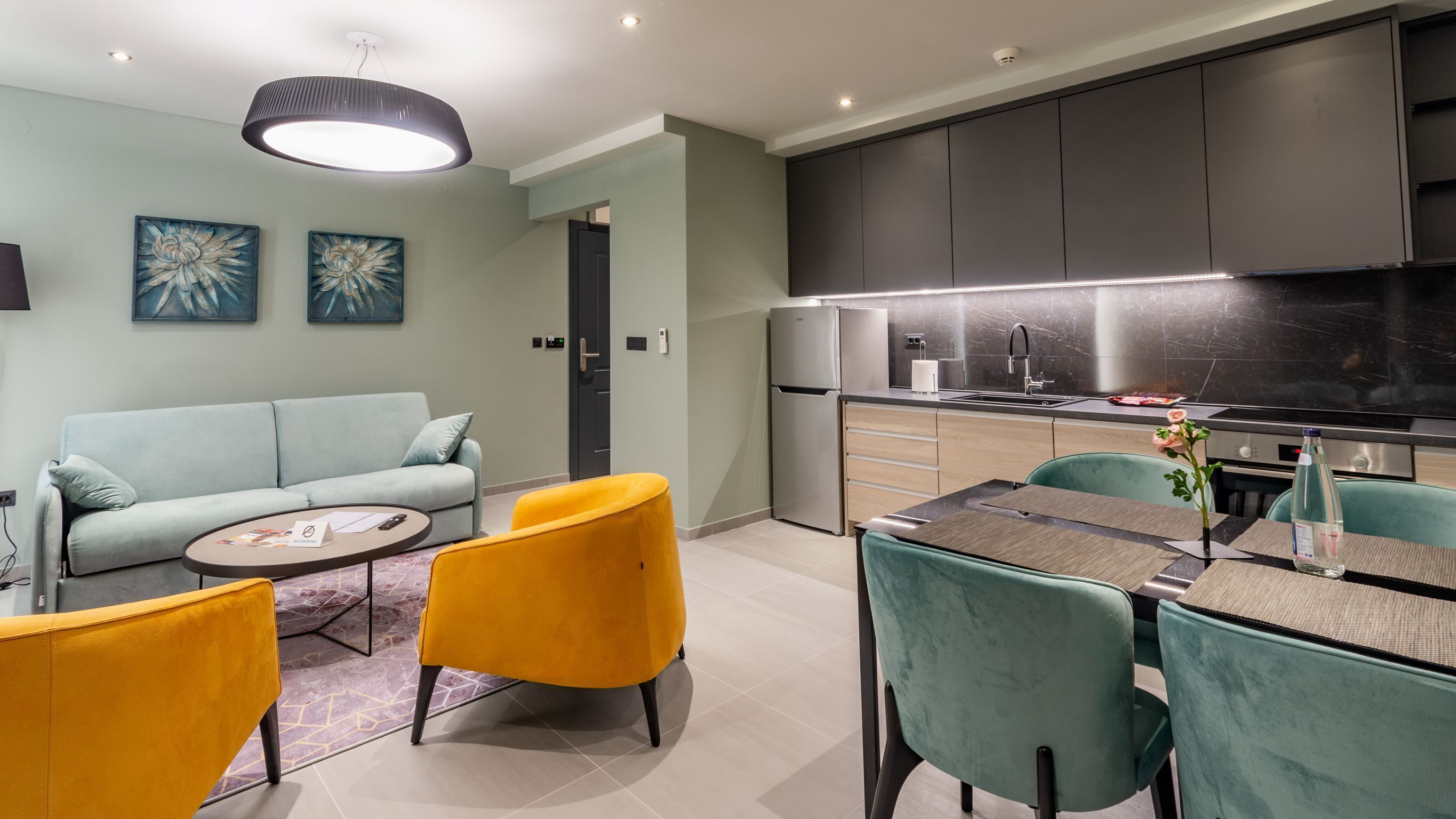Une cuisine moderne dotée d’un four encastré et d’un coin repas avec une table et des chaises.
