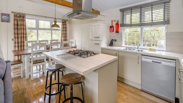 A kitchen with a central island, bar stools, a dishwasher, and a window with blinds. - 1 bedroom accommodation in Bewaldeth, Keswick (Bewaldeth, Keswick)