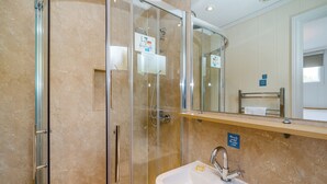 A bathroom with a glass-enclosed shower, a sink with a soap dish, a mirror, and a towel rack. - 1 bedroom accommodation in Bewaldeth, Keswick (Bewaldeth, Keswick)