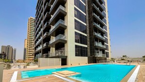Un moderno edificio de apartamentos con piscina en la azotea.