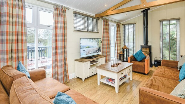 A cozy living room with a sofa, a coffee table, a TV, and a fireplace. - 4 bedroom accommodation in Bewaldeth, Keswick (Bewaldeth, Keswick)