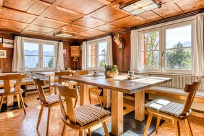 A wooden dining area with a long table, chairs, and a bench. - Berghaus Tschengla (Buerserberg)