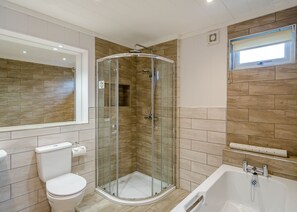 Ein modernes Badezimmer mit einer Duschkabine, einer Toilette und einer Badewanne.