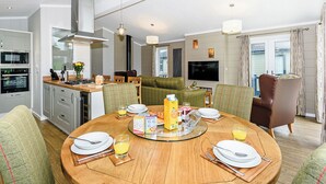 Een moderne keuken met een eethoek, een televisie en een balkon.