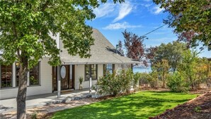 A house with a well-maintained lawn, a visible front door, and a clear view of the sky. - Amazing Lake View Home w Pool table Ping-Pong BBQ Deck, Watch Sunset  (Kelseyville)