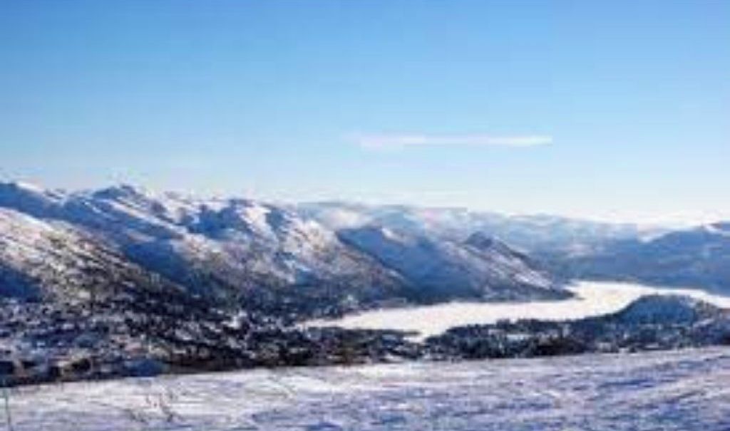 Et snøklædt bjerglandskab med klar himmel.