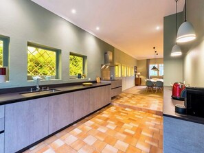 A modern kitchen with a central island, built-in appliances, and a dining area with a table and chairs.