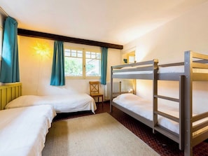 A room with two bunk beds, a chair, a radiator, and a window with curtains. - Holiday home with idyllic terrace on the bay A0372 (Cap Ferret)