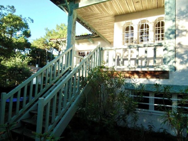 A staircase leading to a building with a balcony.