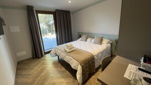 Une chambre d’hôtel avec un lit, un bureau et une vue sur l’extérieur.