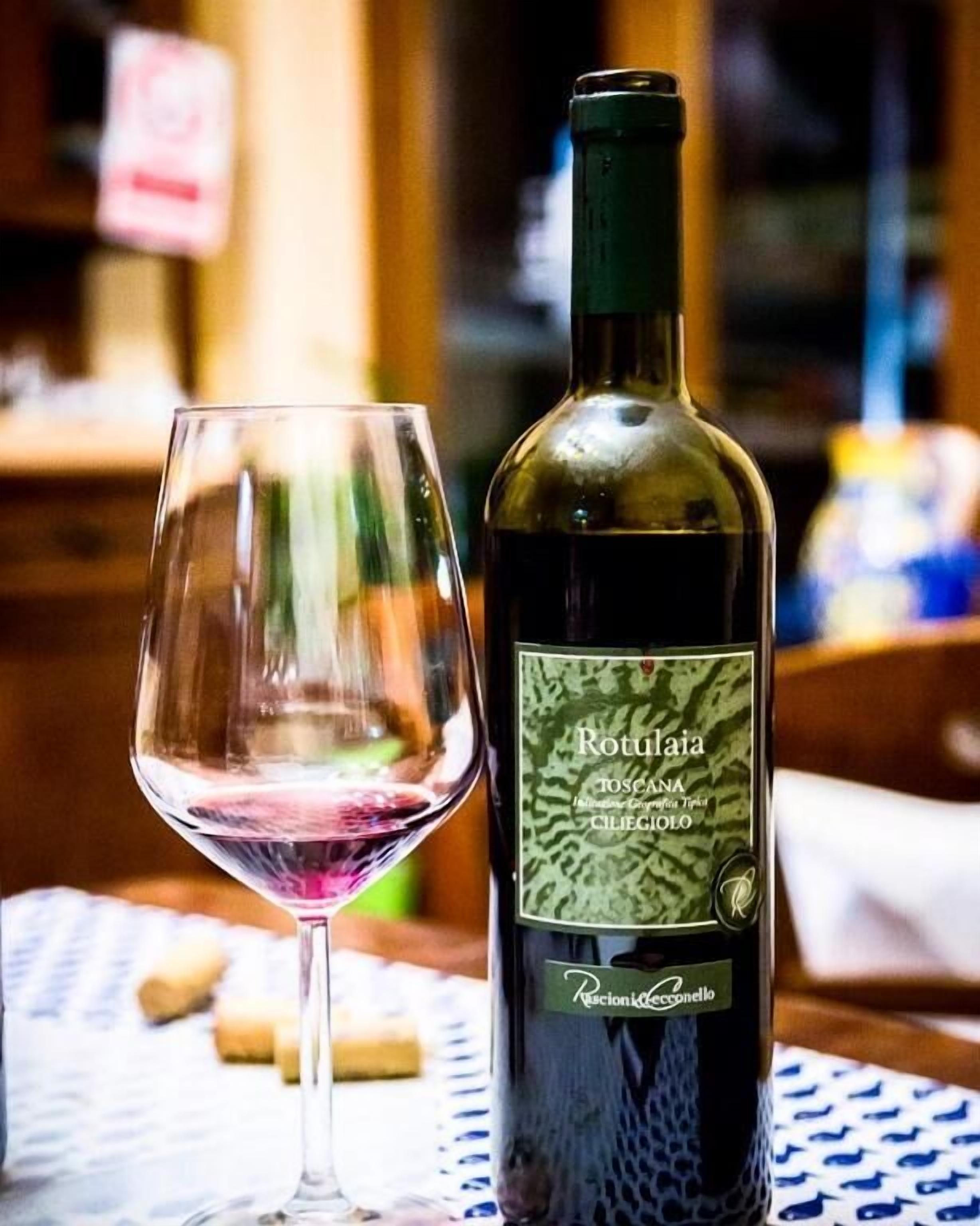 Una botella de vino Rotulaja y un vaso vacío sobre una mesa.