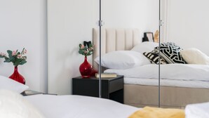 Une chambre à coucher moderne avec un lit, des tables de chevet et un miroir.