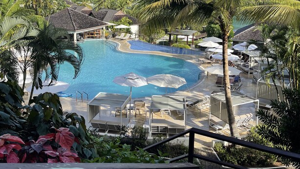 Ein Resort mit Schwimmbad, Liegestühlen und Sonnenschirmen.
