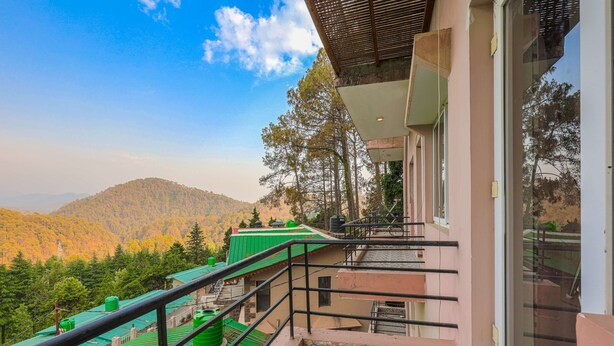 A balcony with a view of a forested mountain range. - IVA 1 BHK - w/ Wi-Fi, Kitchen, Food, Balcony, Garden (Sukha)