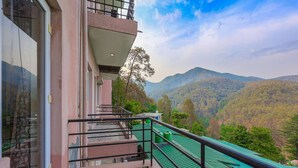 A hotel with a balcony overlooking a mountainous landscape. - IVA 1 BHK - w/ Wi-Fi, Kitchen, Food, Balcony, Garden (Sukha)