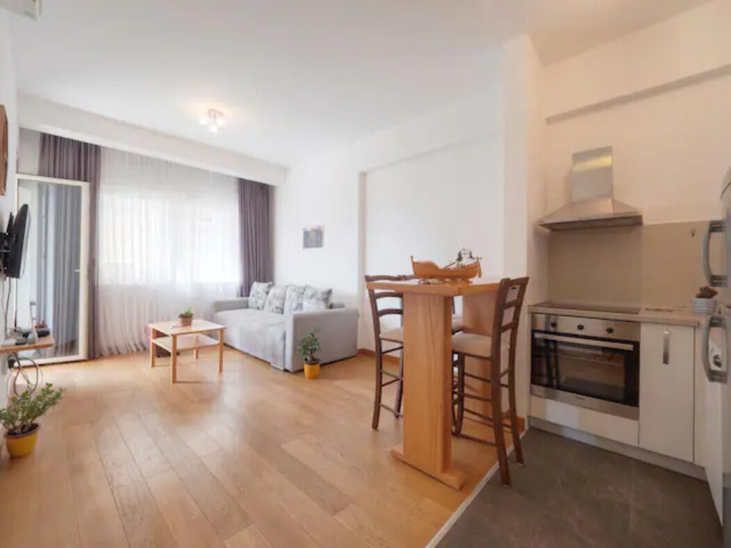 A modern apartment with a living room, a dining area, and a kitchen.