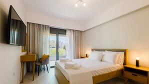 A modern hotel room with a bed, bedside tables, a desk, a chair, and a TV. - Violet Maison (Kos)