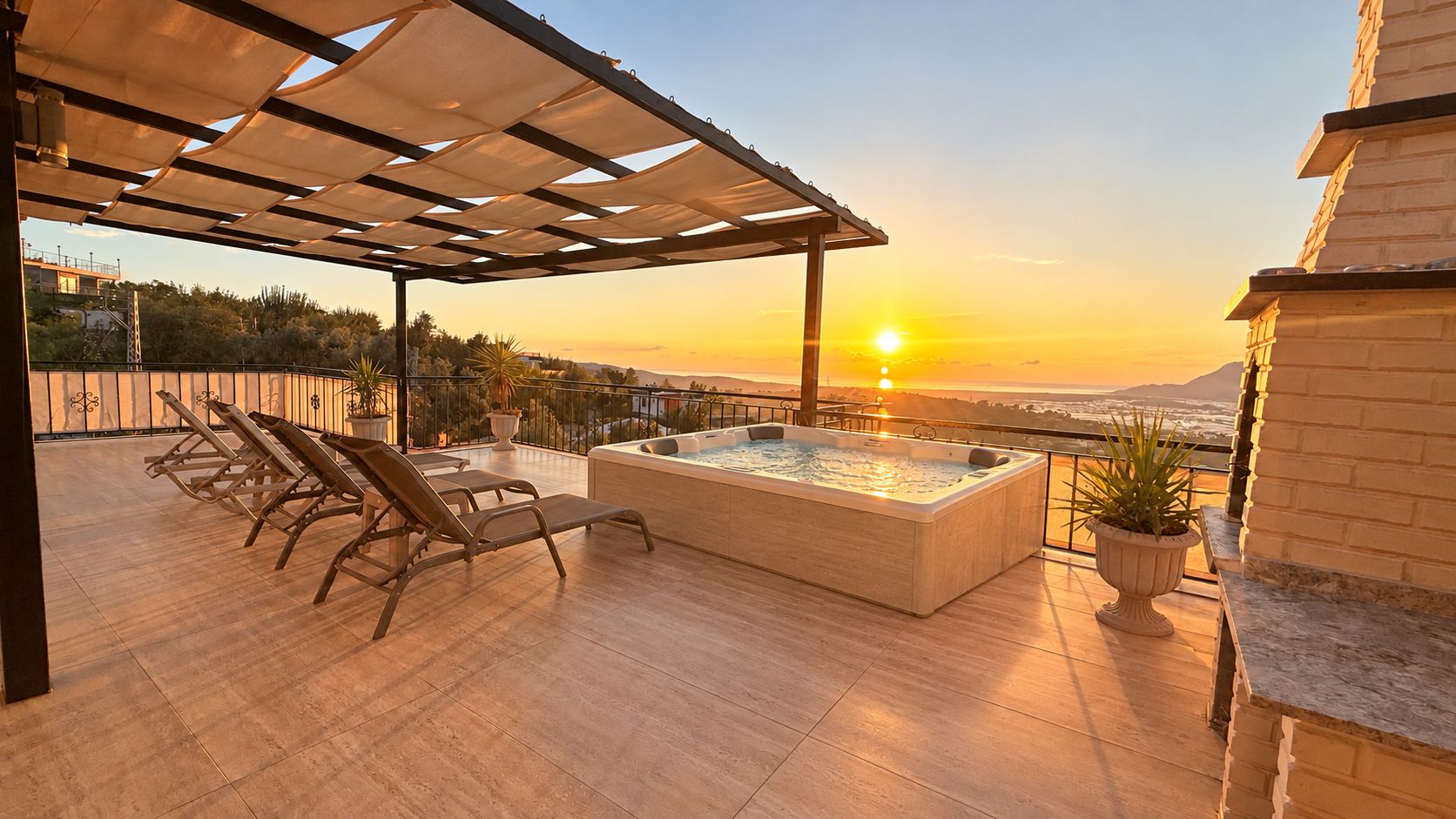 Een terras op het dak met een jacuzzi, lounge stoelen en uitzicht op de ondergaande zon.