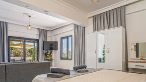 A modern hotel room with a bed, a sofa, a TV, and a wardrobe. - Villa sahin-1 in Uzumlu private villa with stunning views.POOL HEATER Available. (Kas Kalkan Antalya)